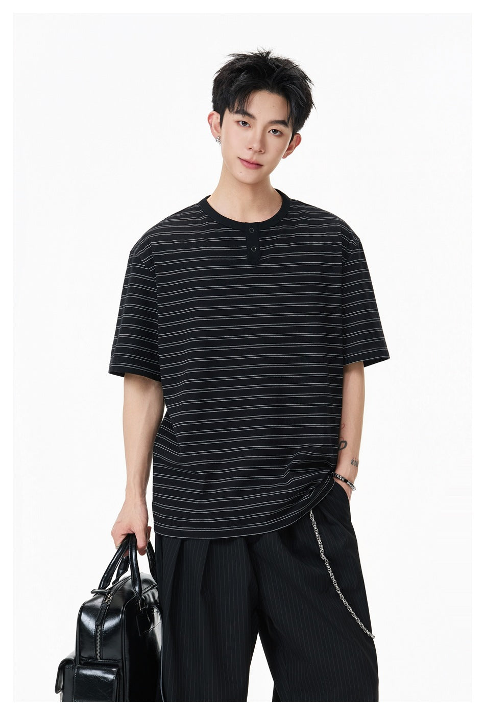 Model wearing a black short-sleeve shirt with fine horizontal stripes and a two-button placket.