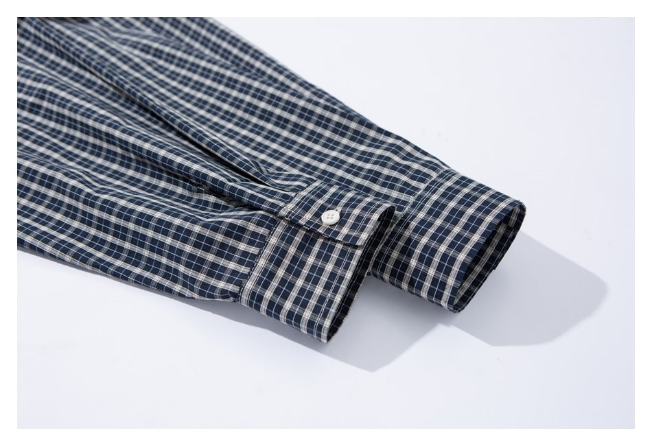 Close-up of the navy checked shirt's buttoned cuff and sleeve.