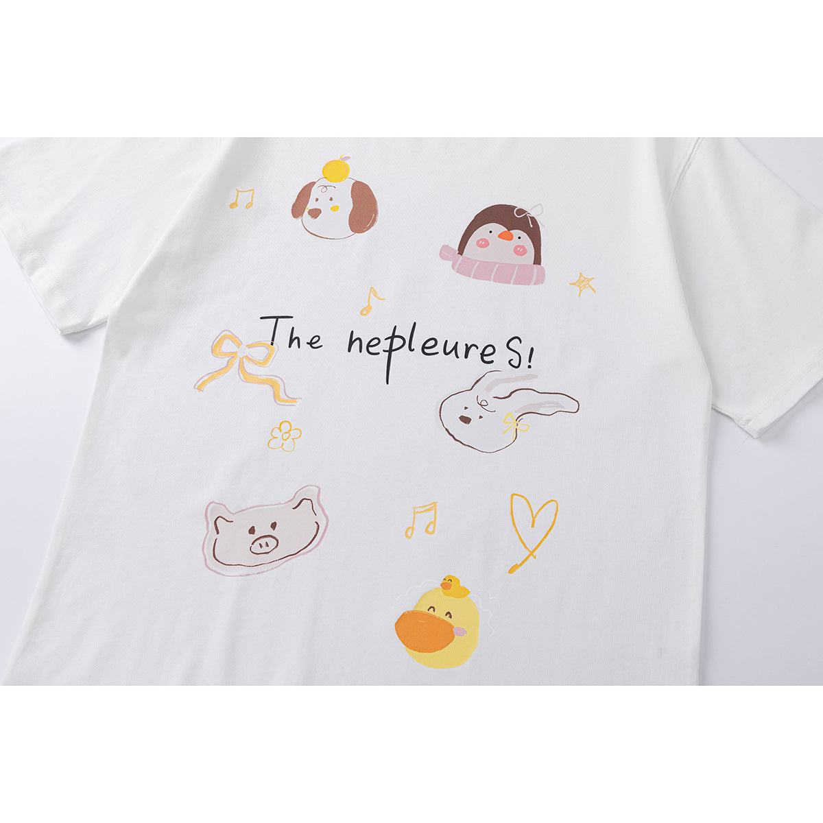 Close-up of a white T-shirt front with playful pastel animal, music note, bow and heart graphics and English lettering.