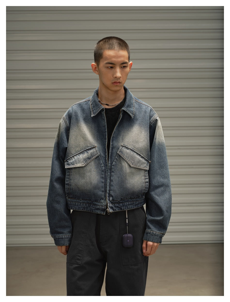 Front view of a model wearing a faded blue denim jacket with two large flap pockets and black trousers.