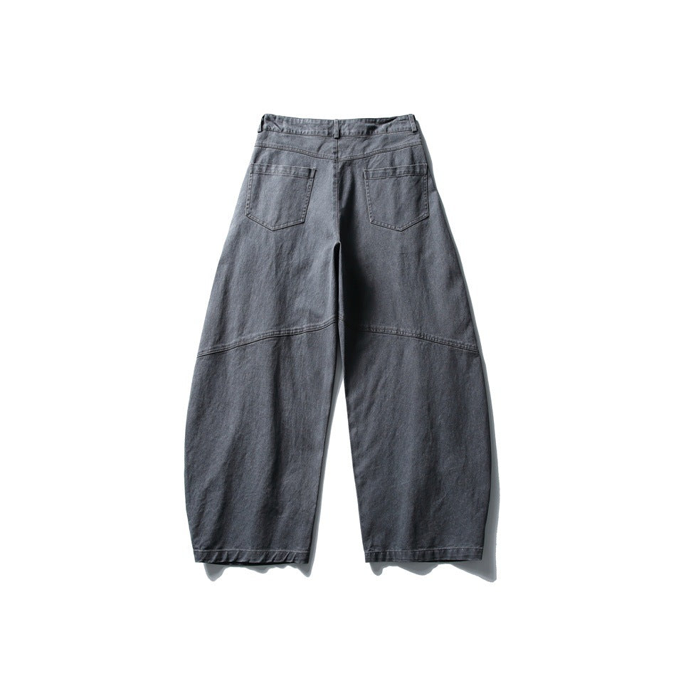 Back view of dark gray wide-leg pants with two patch pockets and curved seams across the legs
