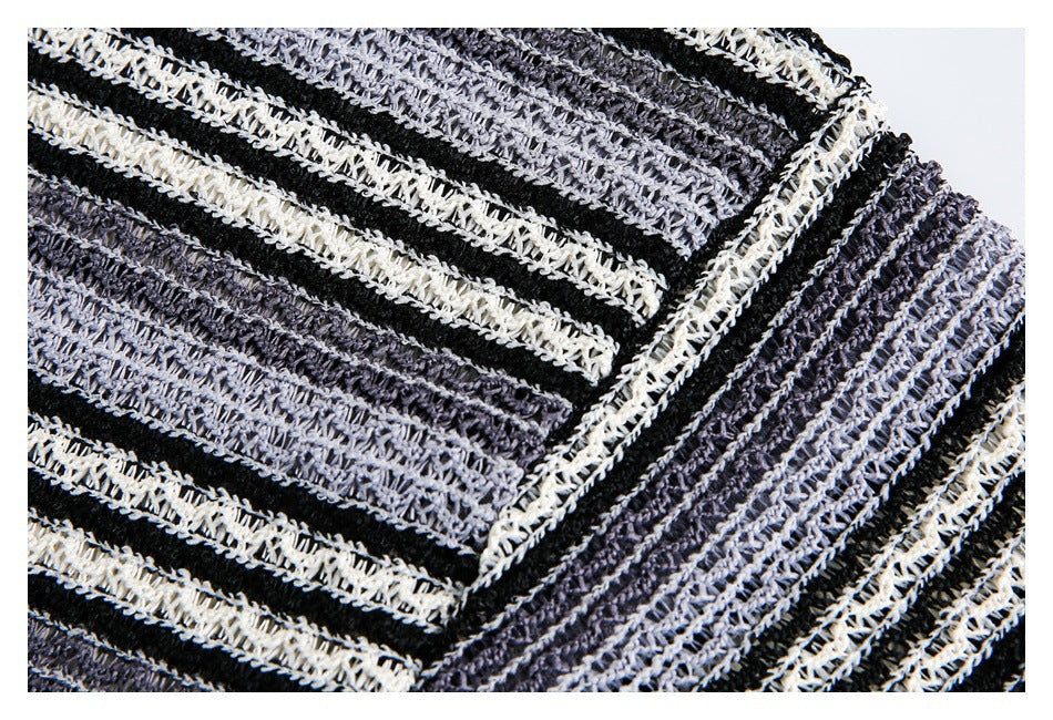 Close-up of a stitched seam joining black, charcoal, and ivory striped open-knit fabric.