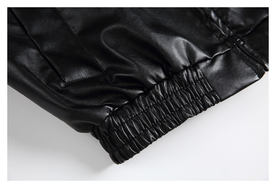 Close-up of the black jacket's gathered elastic hem and stitched panel.