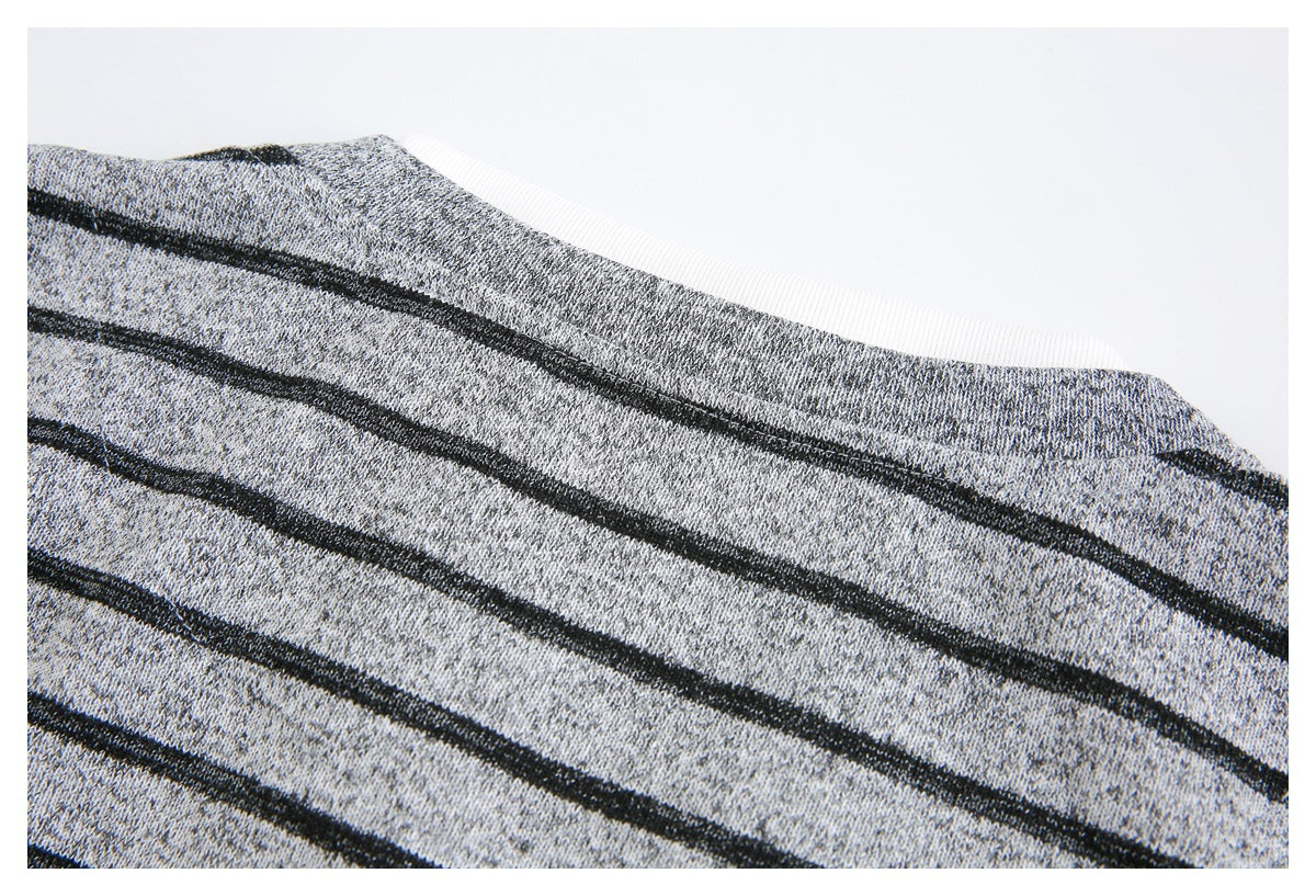 Close-up of a gray-and-black striped garment neckline with white ribbed inner trim.