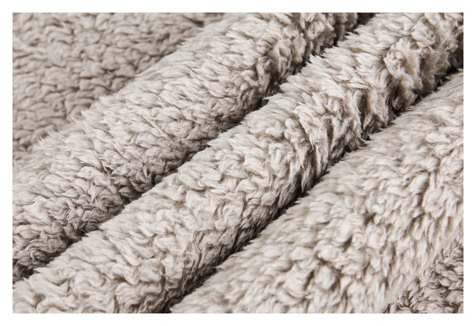 Close-up of light beige plush fabric folded into soft ridges, showing its curly pile.