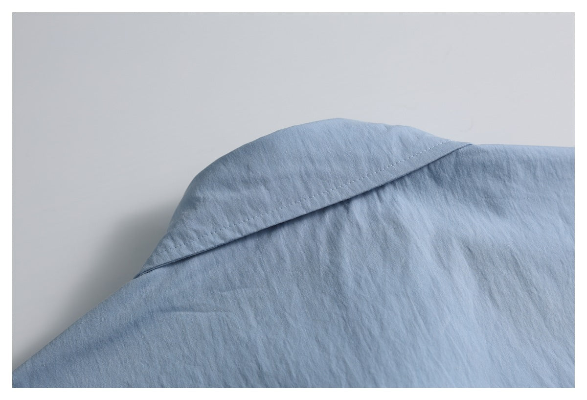 Close-up of the light blue shirt's collar seam and shoulder area.