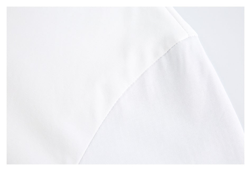 Close-up of a diagonal stitched seam on white shirt fabric.