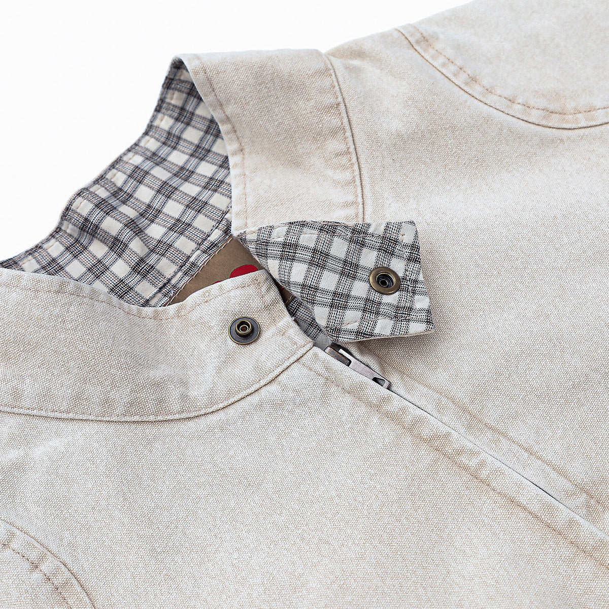 Close-up of the beige jacket collar, showing plaid lining, snap buttons, and textured fabric.