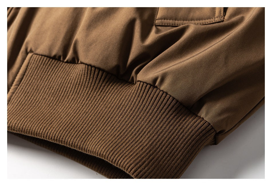 Close-up of a brown jacket's ribbed hem and smooth outer fabric.