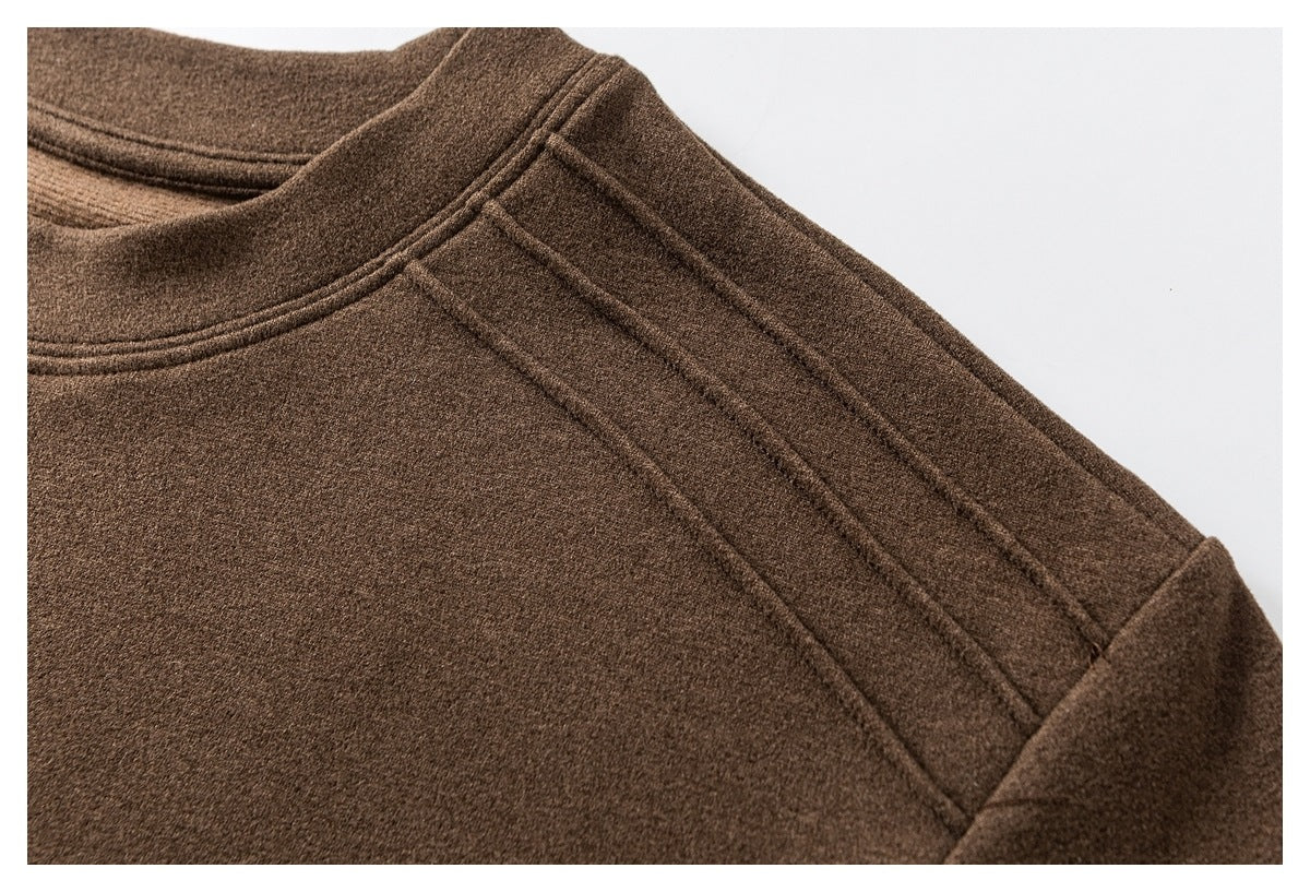Close-up of the brown top's neckline and layered shoulder seam stitching.