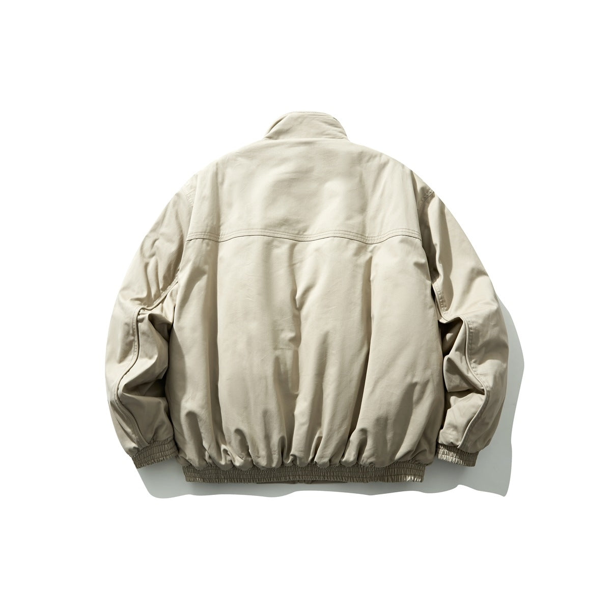 Back view of a light beige stand-collar jacket with long sleeves and gathered cuffs and hem.