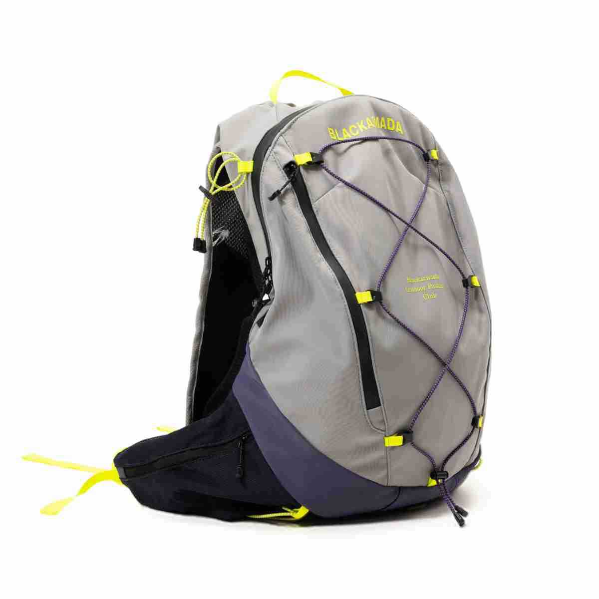 Gray backpack with navy lower panel, purple crisscross cord, neon yellow accents and diagonal front zip, three-quarter view
