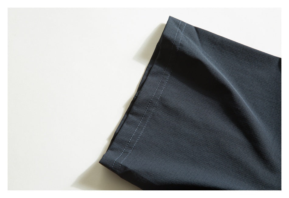 Close-up of the dark shirt sleeve edge and its double-stitched hem.