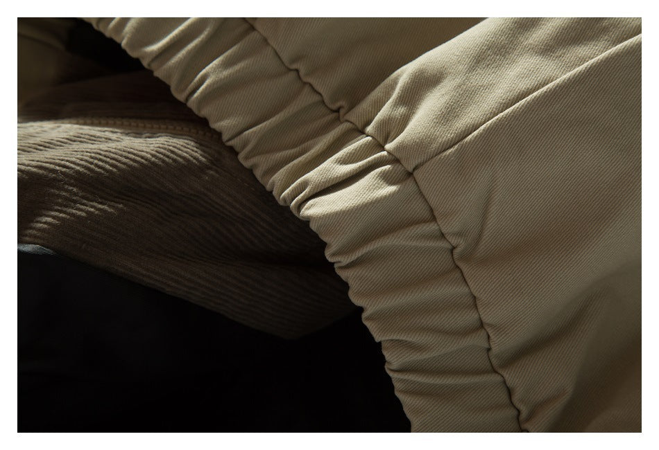 Close-up of gathered beige fabric around an opening, with a darker ribbed section visible inside.
