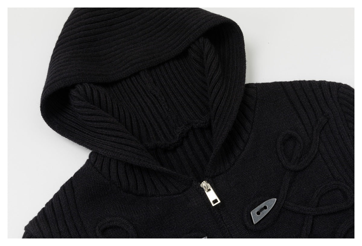 Close-up of black ribbed knit hood, silver zipper pull and toggle button with looped cord detail