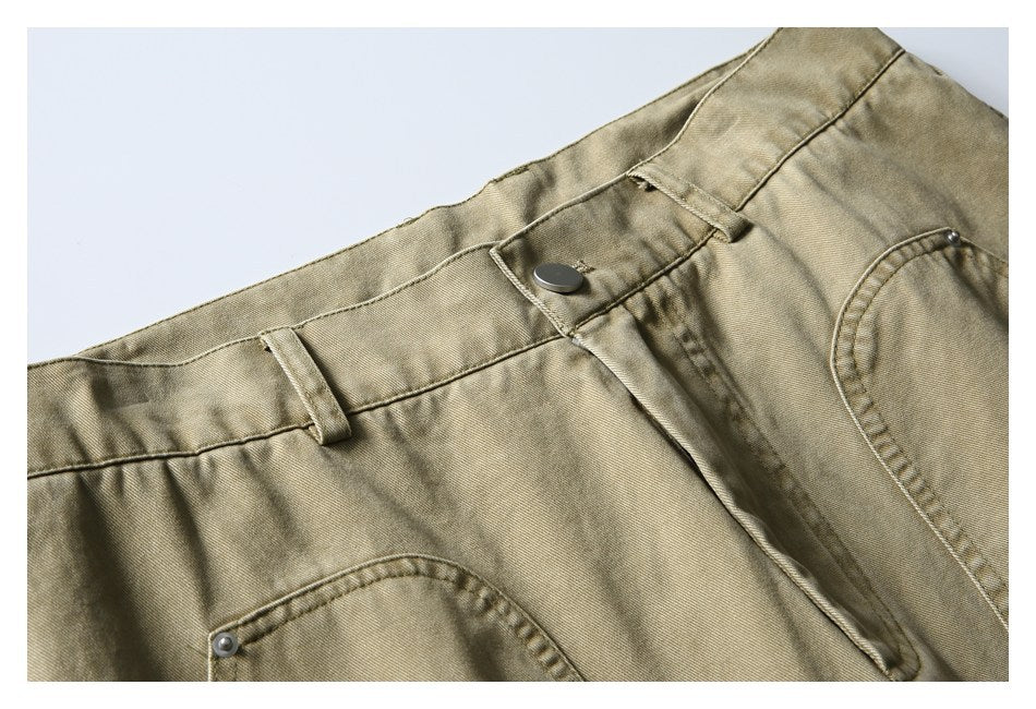 Close-up of khaki pants showing the waistband, button, belt loops, fly, and front pocket.