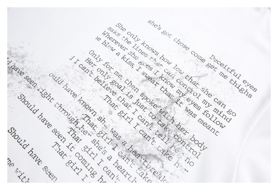 Close-up of distressed black English text artwork printed on white fabric.