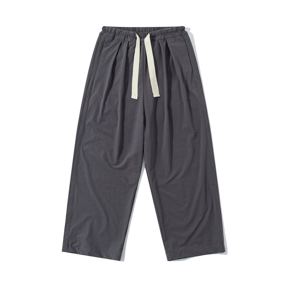 Dark gray wide-leg drawstring pants with elastic waistband and front pleats, flat front view