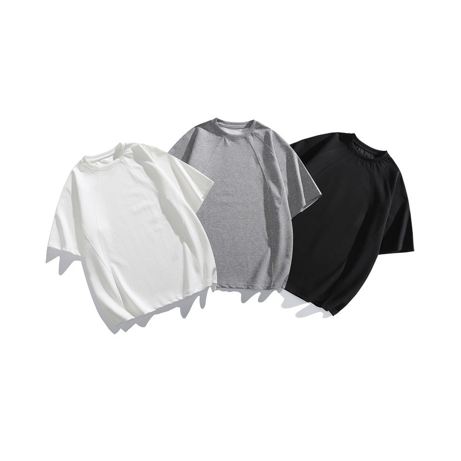 Three short-sleeve crewneck raglan tops shown from the front in white, heather gray, and black.