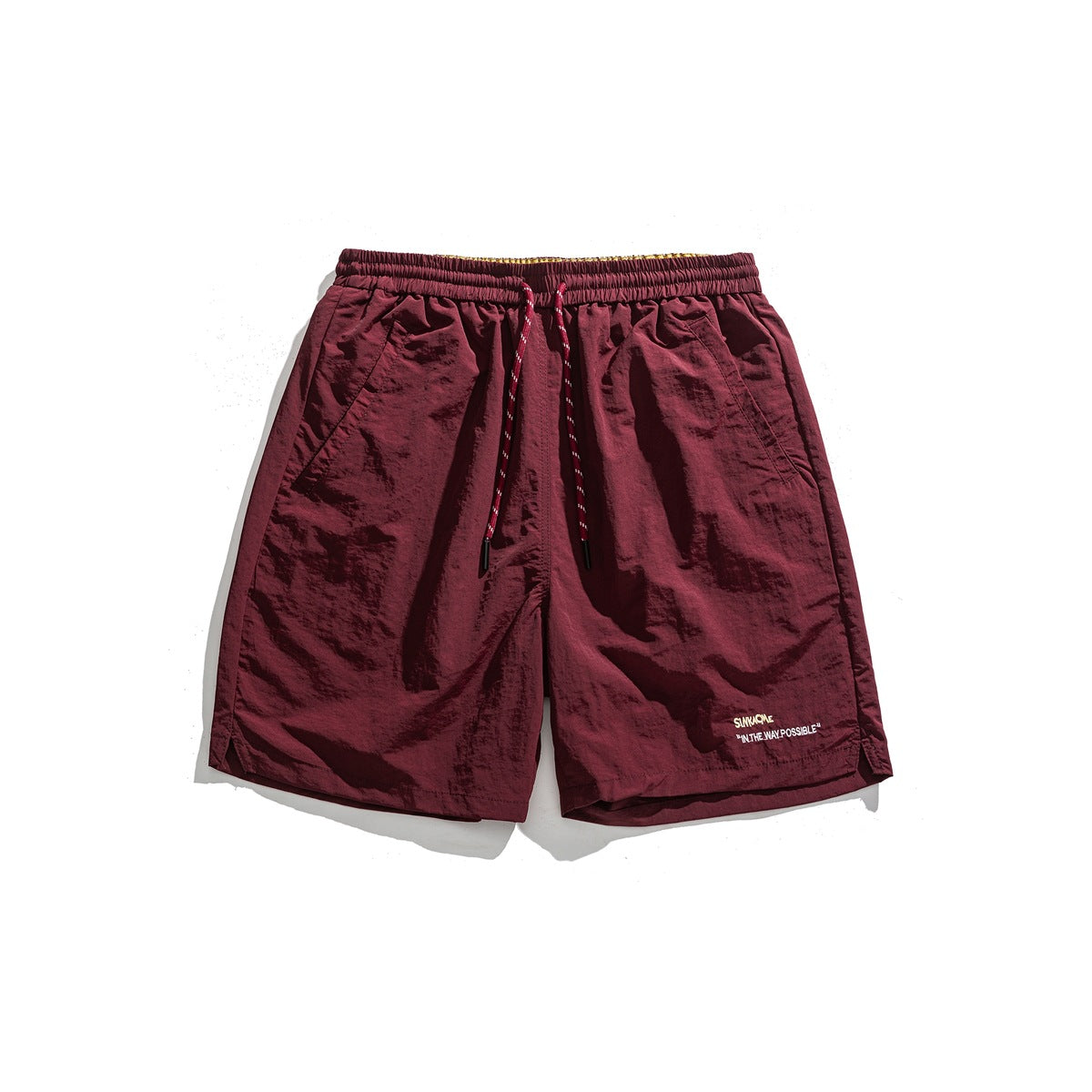 Burgundy drawstring shorts, flat lay front view, with side pockets and small embroidered text on the lower leg