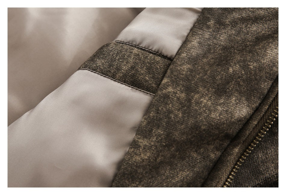Close-up of a brown mottled jacket with light beige lining, a contrasting fabric panel, and a metal zipper.