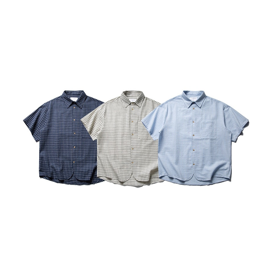 Three short-sleeve button-up shirts shown from the front: navy check, beige check, and light blue textured.