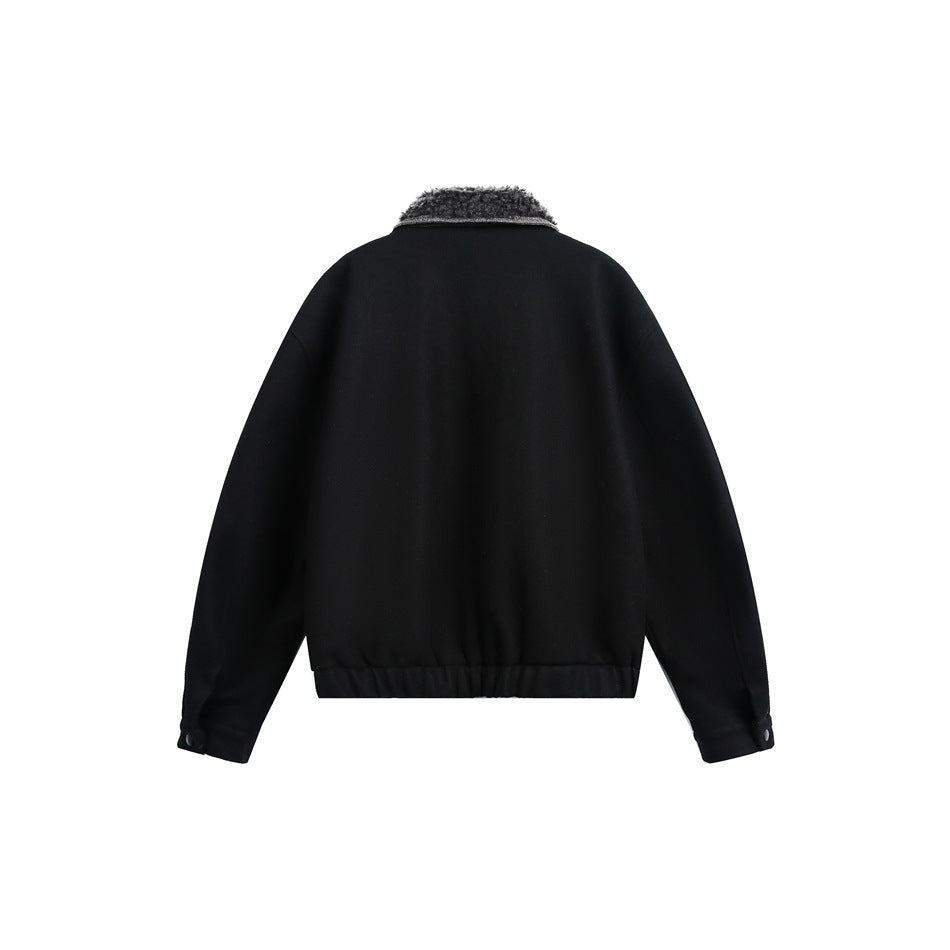 Back view of a black jacket with a textured dark collar, long sleeves and an elasticized hem on a white background.