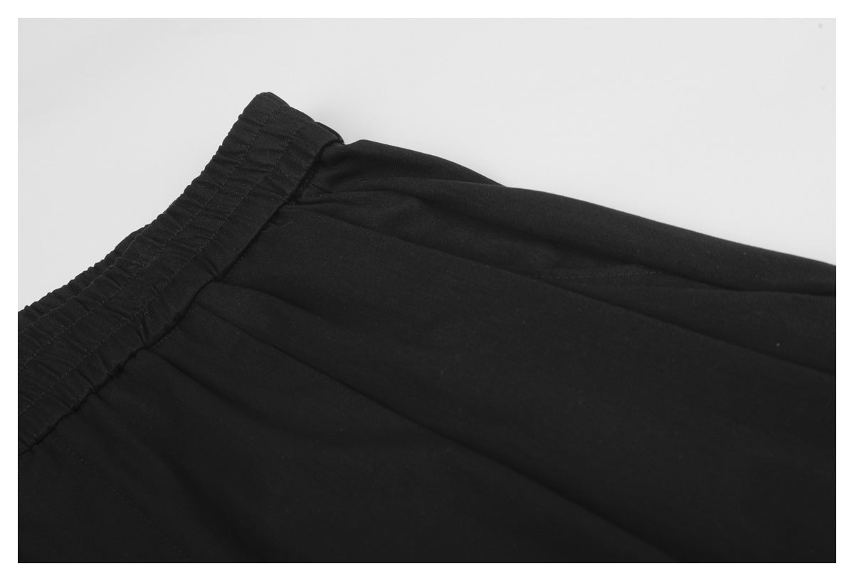 Close-up of black shorts showing the elastic waistband, seam, and fabric panels.