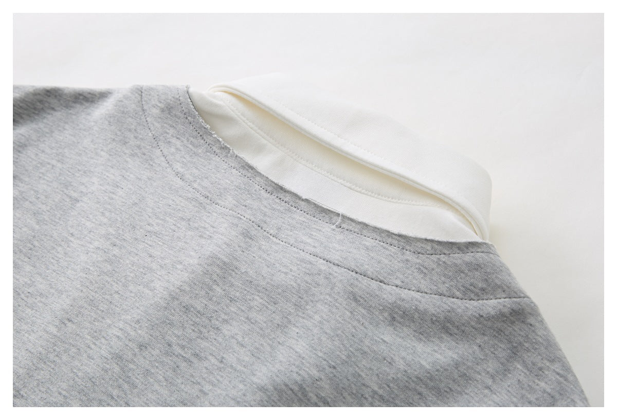 Close-up of a heather gray garment neckline with white inner neck binding.