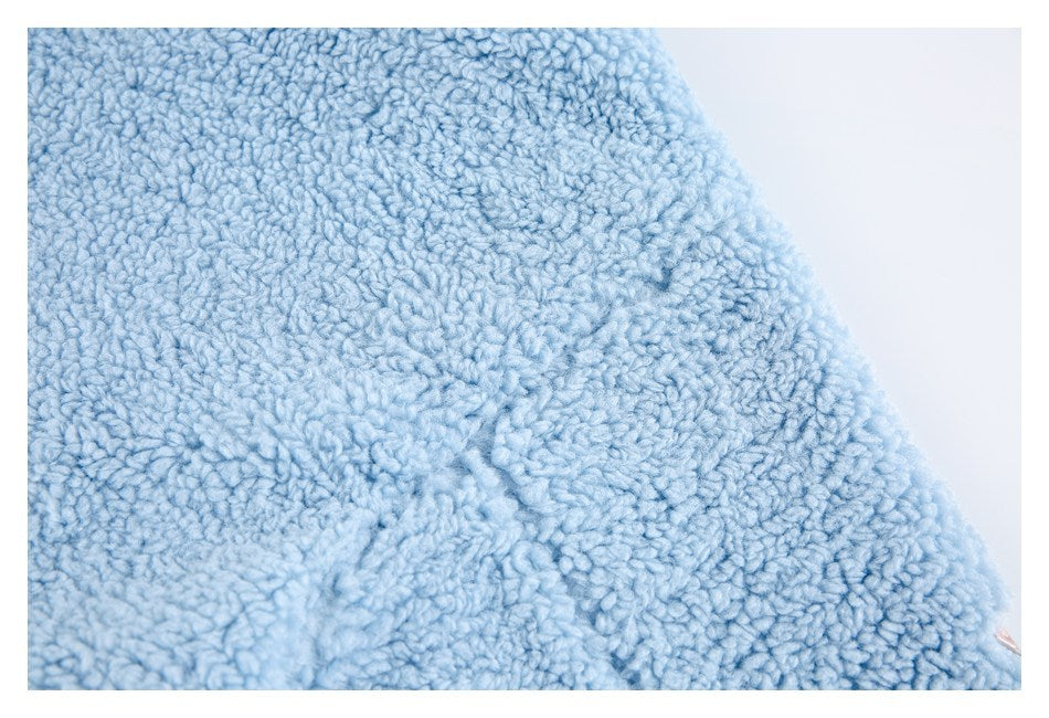 Close-up of the light blue plush garment surface and a curved seam.