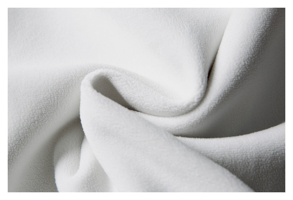 Close-up of folded ivory fabric with a soft, visibly textured surface.