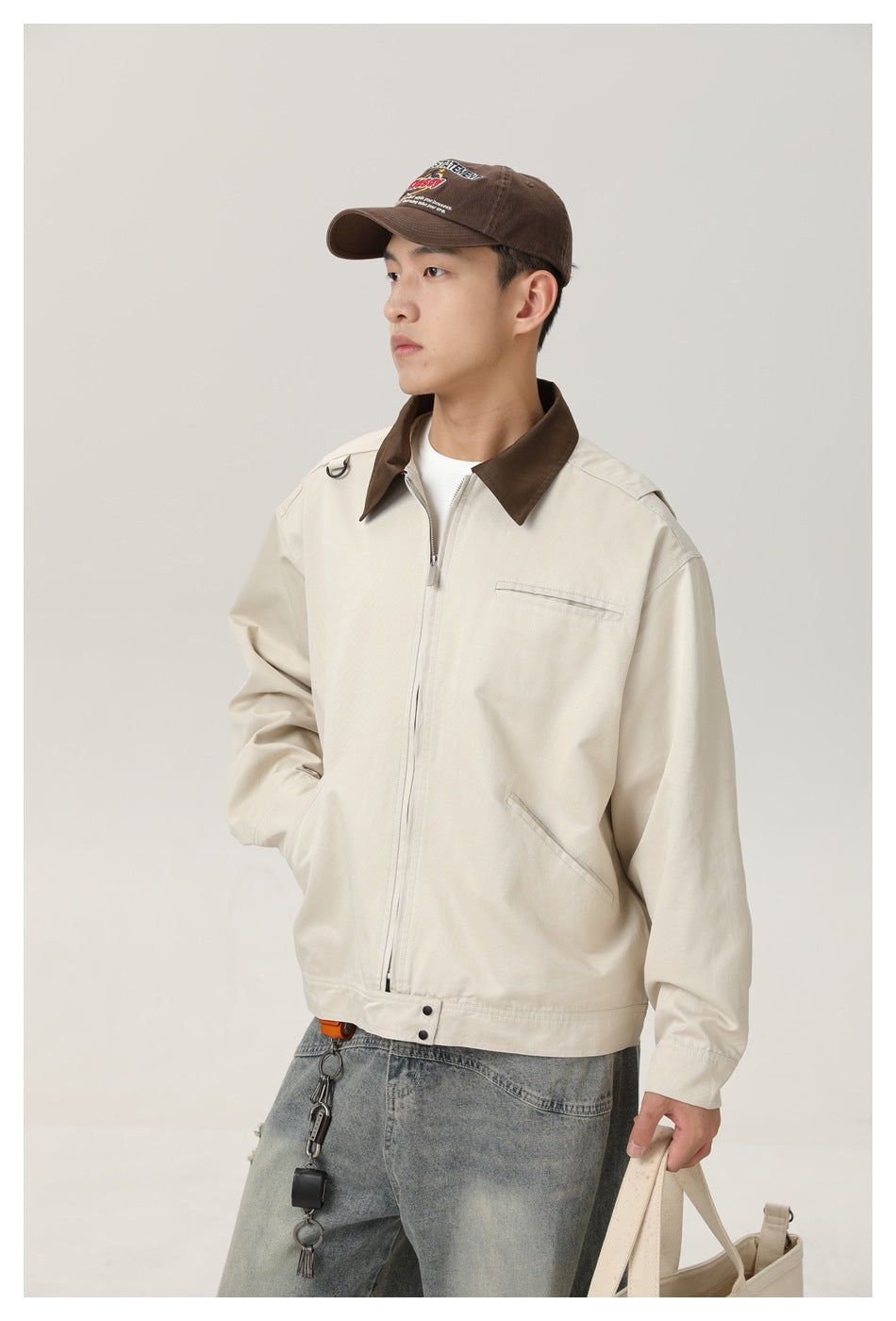 Model wearing an ivory zip jacket with a dark brown collar and a chest pocket.
