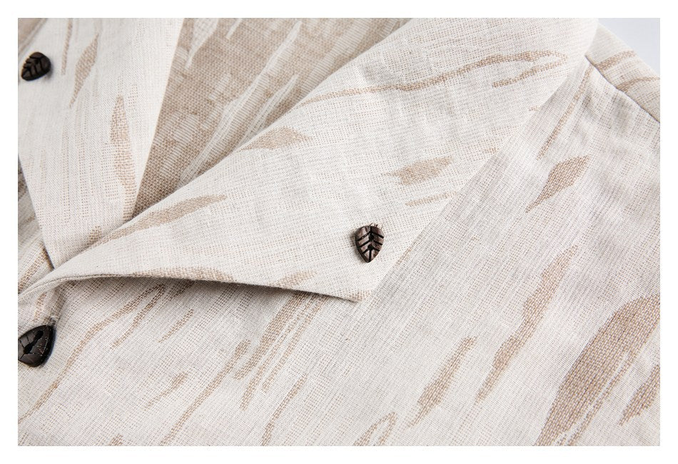 Close-up of the ivory jacket's notched lapel and dark leaf-shaped buttons against tan patterned fabric.