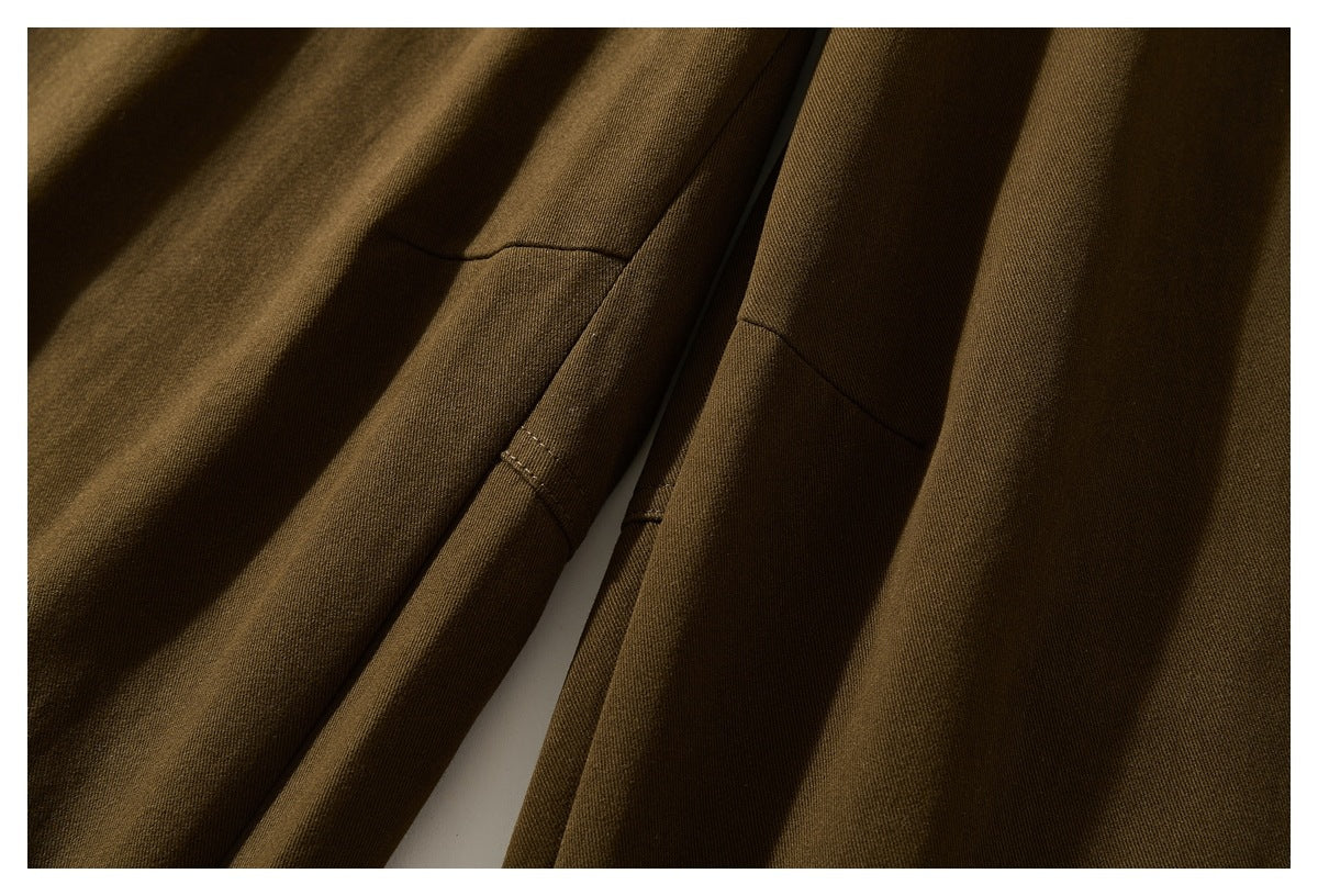 Close-up of olive-brown trouser legs and stitching along the inner seam.
