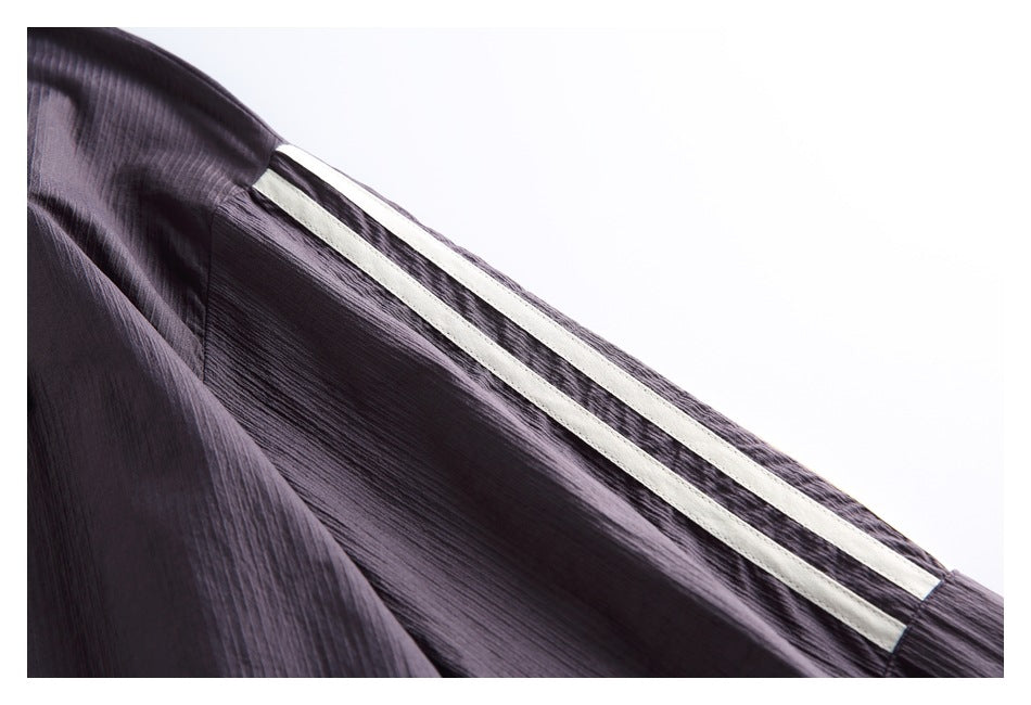 Close-up of a dark plum sleeve with a long cream stripe running along it.