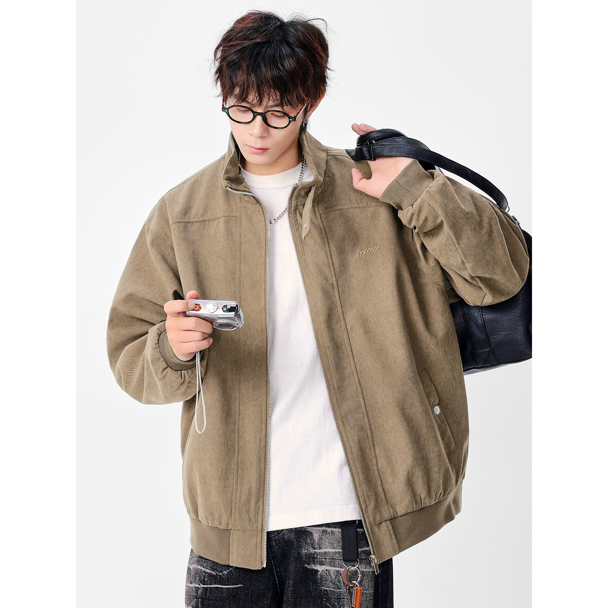 Model wearing a light taupe zip-front jacket with a stand collar, oversized sleeves, and ribbed cuffs and hem.