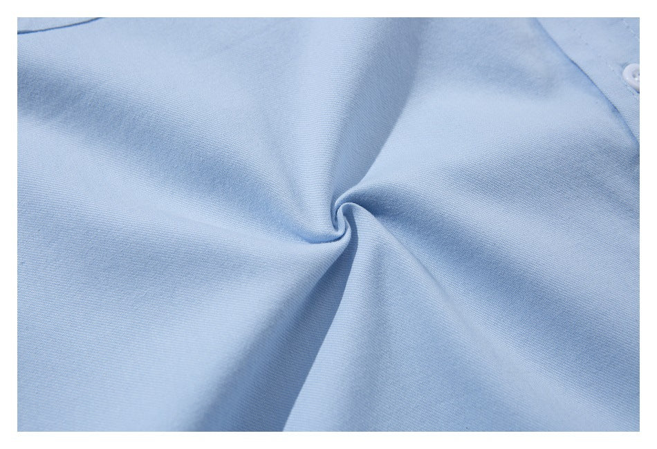 Close-up of light blue shirt fabric gathered into a twist, showing its surface texture.