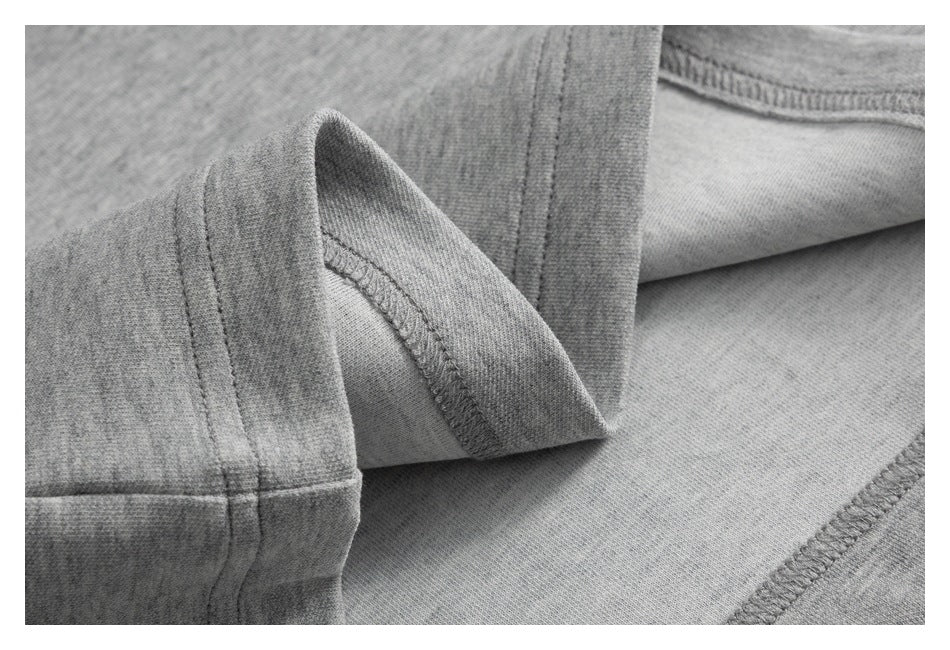 Close-up of gray knit garment fabric folded to show stitched seams and finished edges.