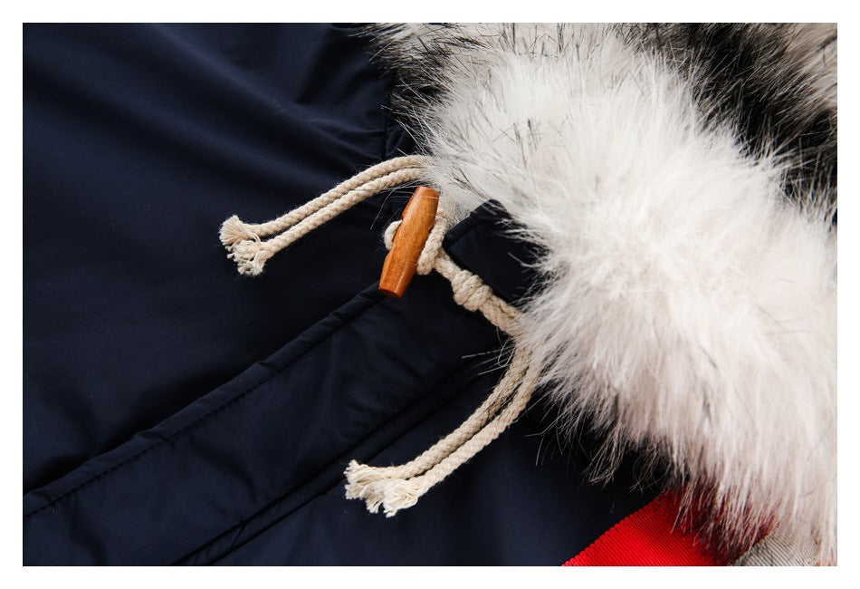 Close-up of cream hood drawcords with wooden toggles beside the jacket's white fur trim.