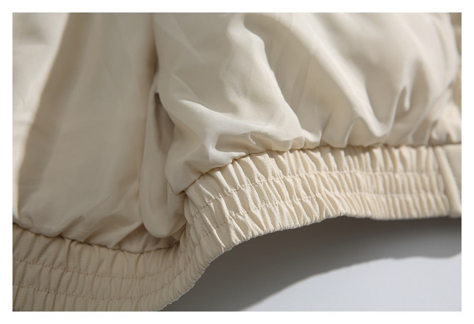 Close-up of a beige jacket's gathered elastic hem.