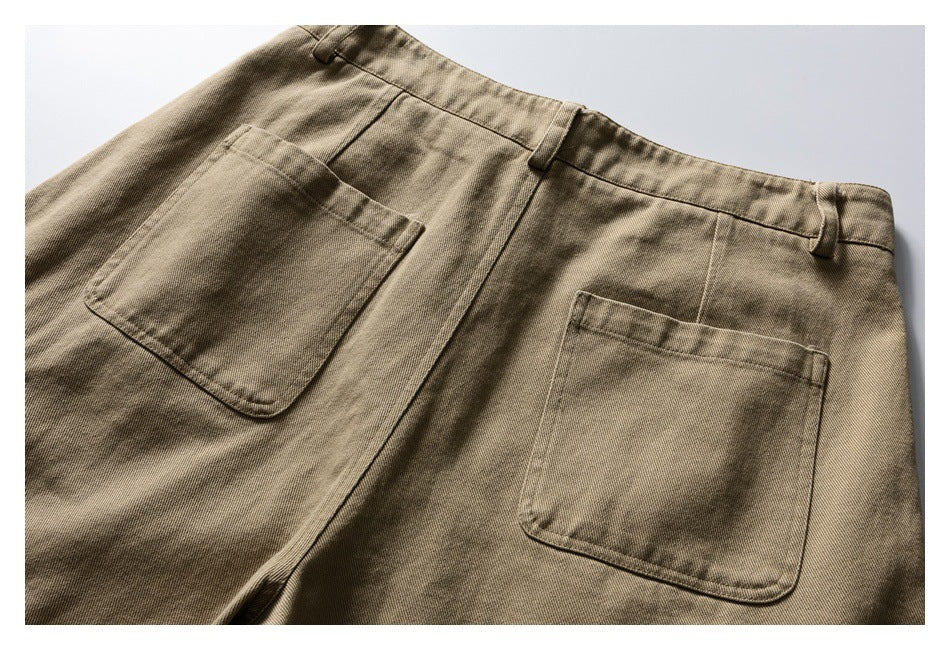 Back view of tan trousers with two patch pockets, a center seam, and belt loops.
