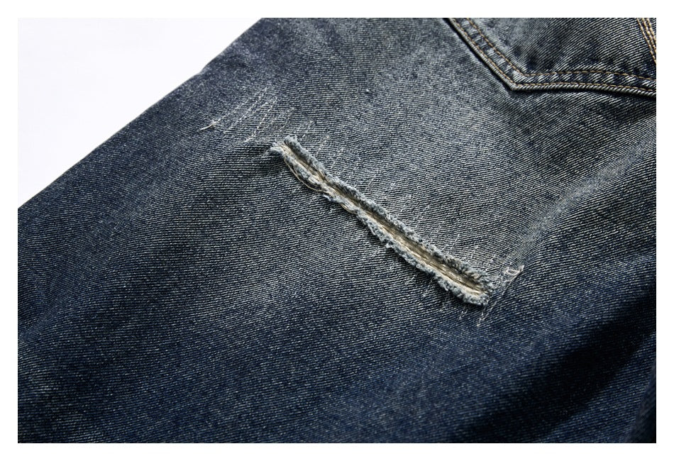 Close-up of dark washed jeans with a long frayed distressed slash below a pocket.