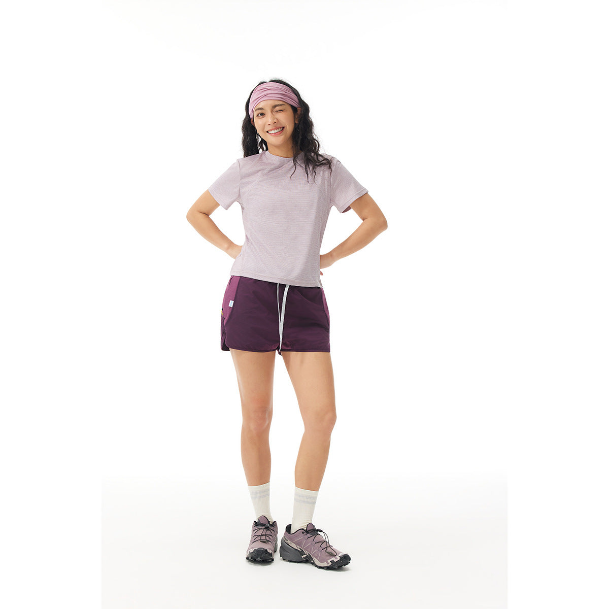 Model wearing a pale lavender short-sleeve shirt and plum drawstring shorts, shown from the front.