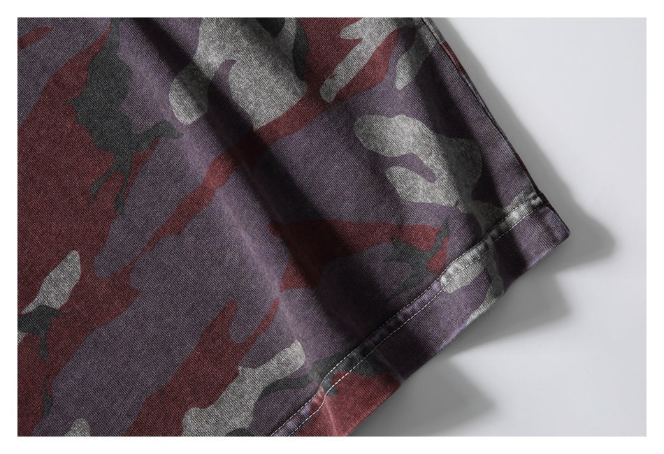 Close-up of the short sleeve and stitched cuff on a maroon, gray, and dark camouflage shirt.
