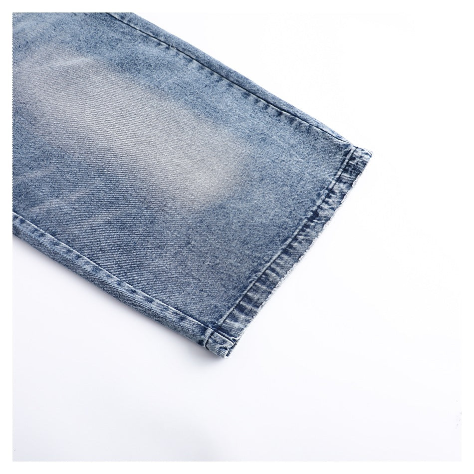 Close-up of a blue denim garment hem with visible stitching and a washed finish.