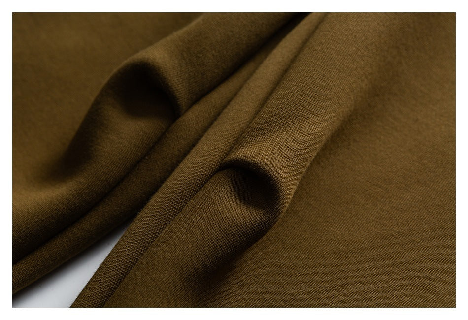 Close-up of ochre fabric arranged in soft folds, showing its surface texture.