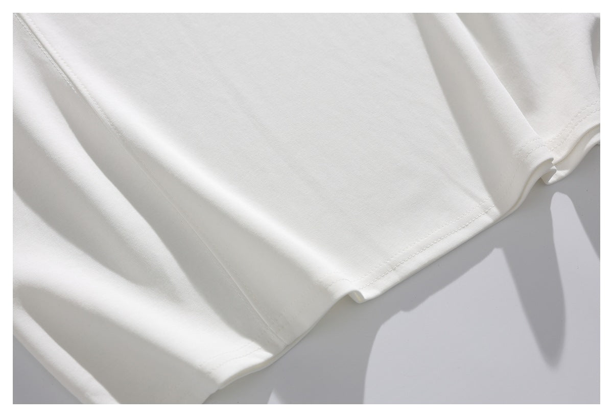 Close-up of a white garment's stitched hem and folded fabric.