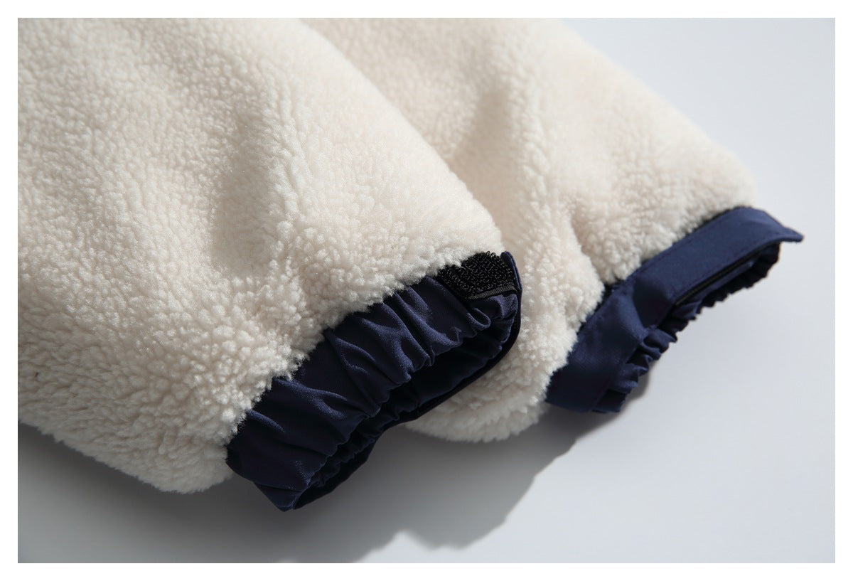 Close-up of cream sherpa jacket cuffs with dark navy adjustable trim and hook-and-loop tabs.