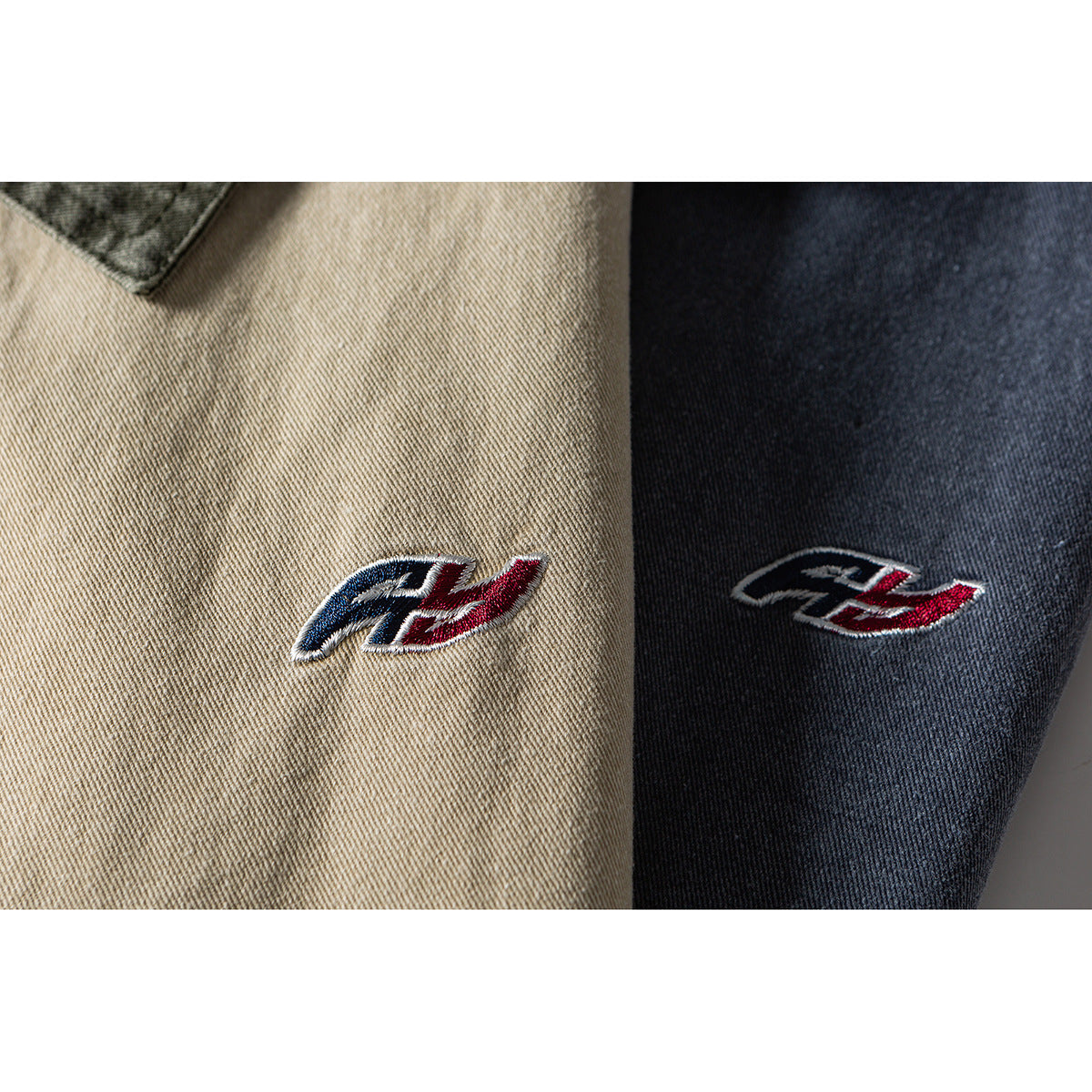 Close-up of a small red, white, and navy embroidered emblem on beige and dark blue jacket fabric.