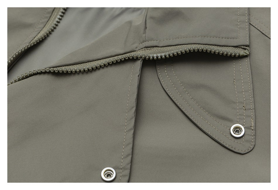 Close-up of an olive-gray garment panel with an open zipper and snap-fastened flap.